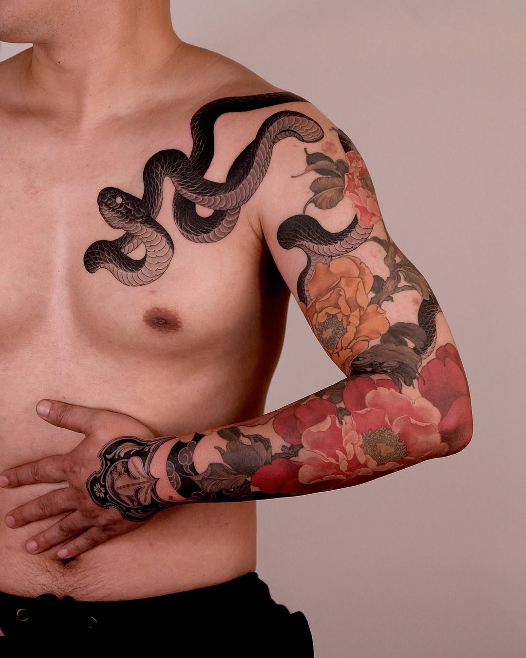 Elegant snake tattoo accentuated with flowers Tattoo Design