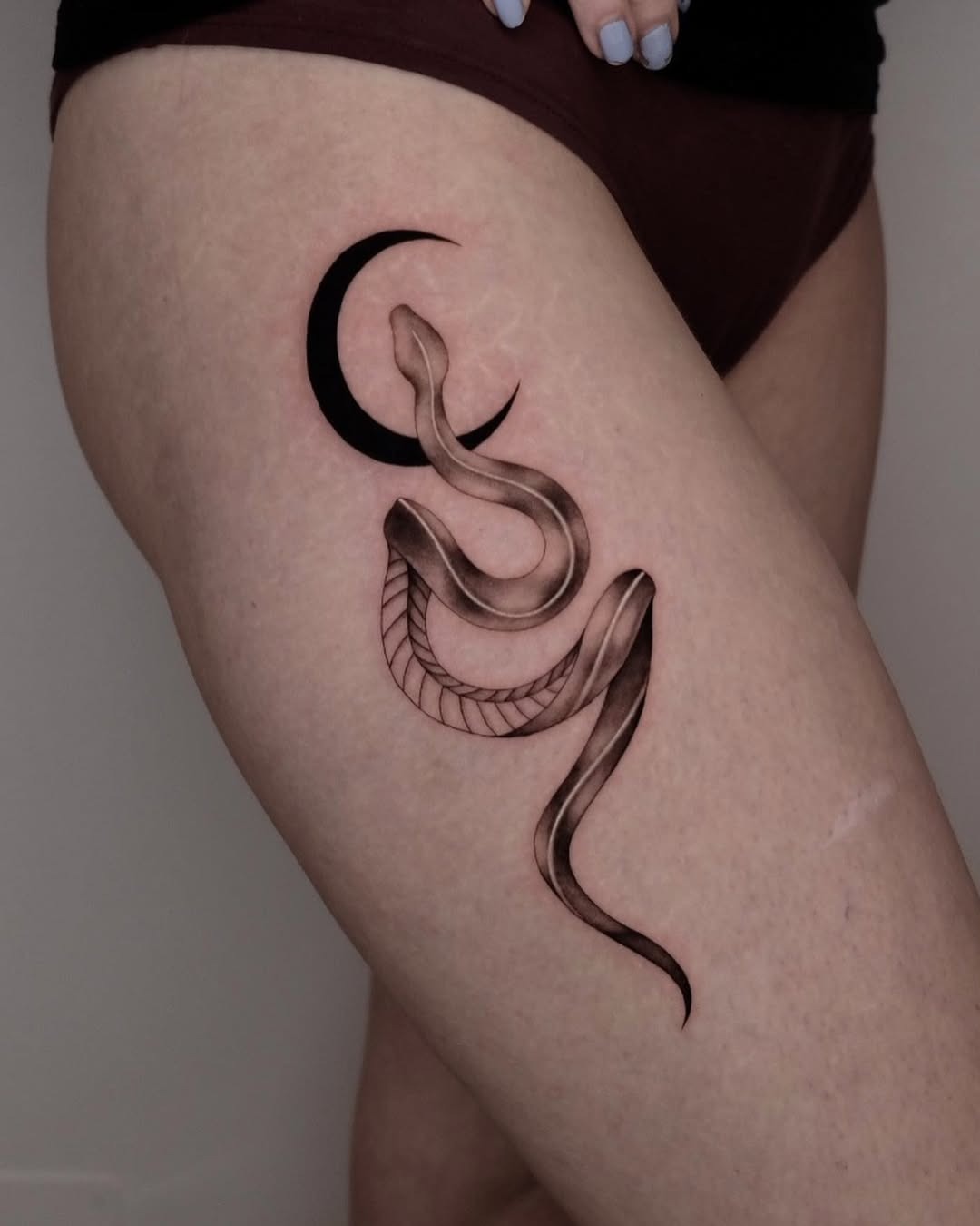 Elegant snake tattoo entwined with a crescent moon Tattoo Design