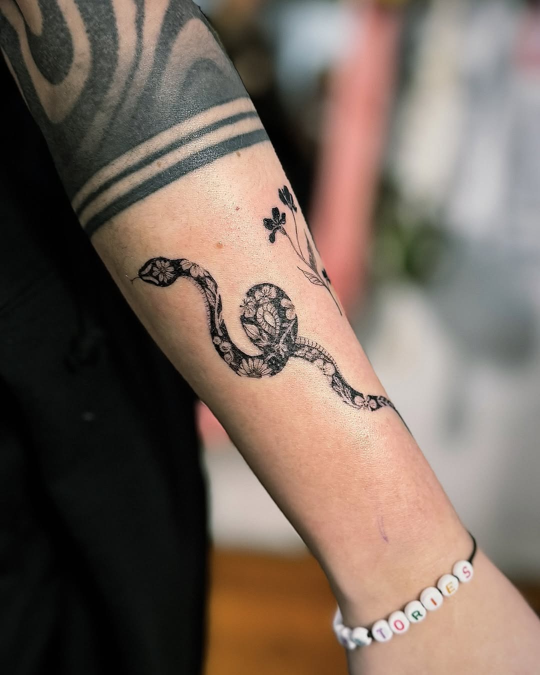 Elegant snake tattoo with floral accents Tattoo Design