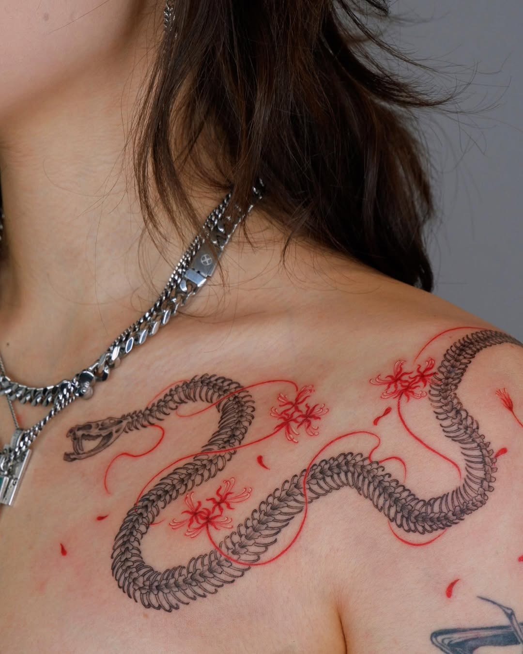 Elegant snake tattoo with floral accents Tattoo Design
