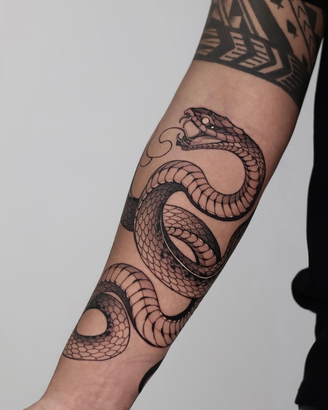 Intricate black ink snake tattoo on forearm Tattoo Design