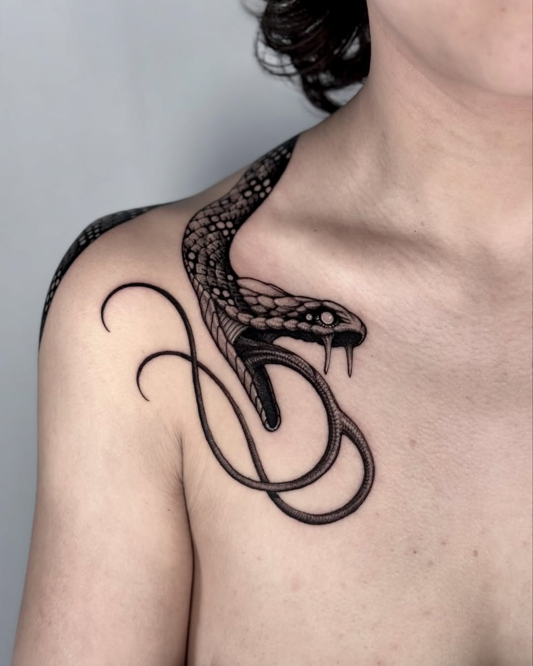 Intricate black snake tattoo on shoulder area Tattoo Design