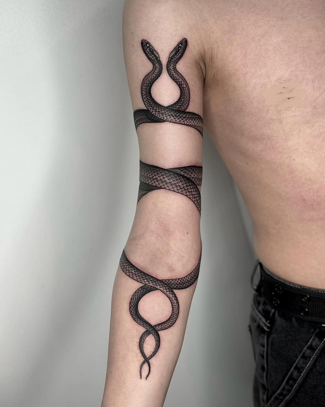 Intricate black snake tattoo wrapping the arm Tattoo Design