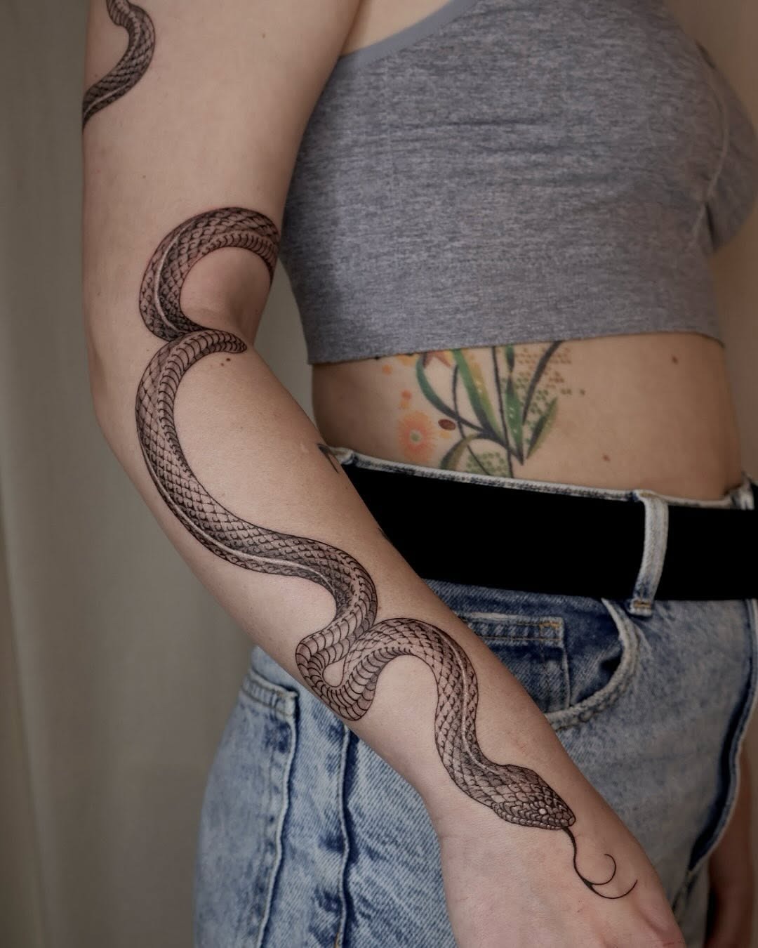Intricate snake tattoo wraps around the arm Tattoo Design
