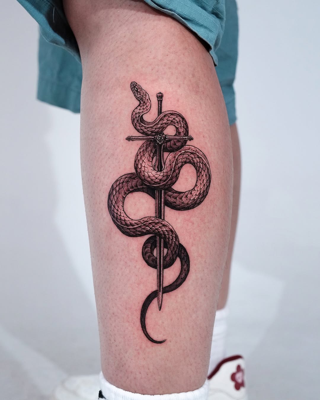 Striking snake and sword tattoo design Tattoo Design