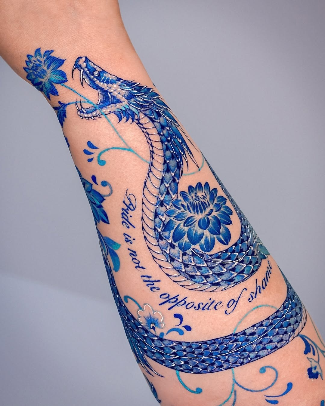Stunning Blue Snake Tattoo with Floral Elements Tattoo Design