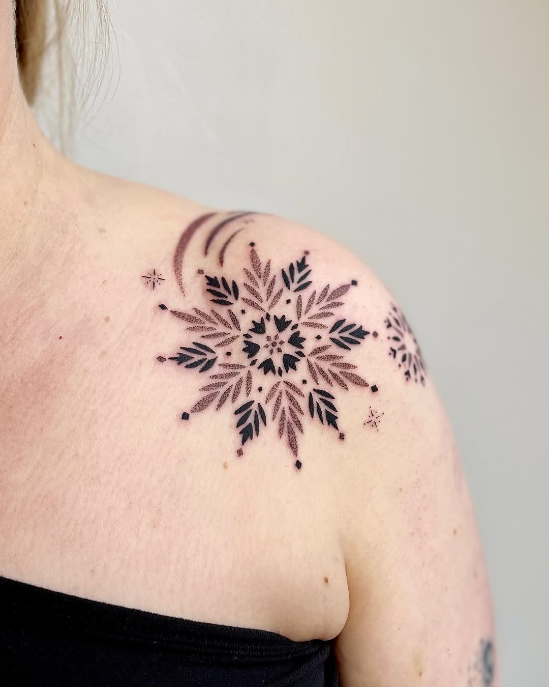 Charming snowflake tattoo on the shoulder. Tattoo Design