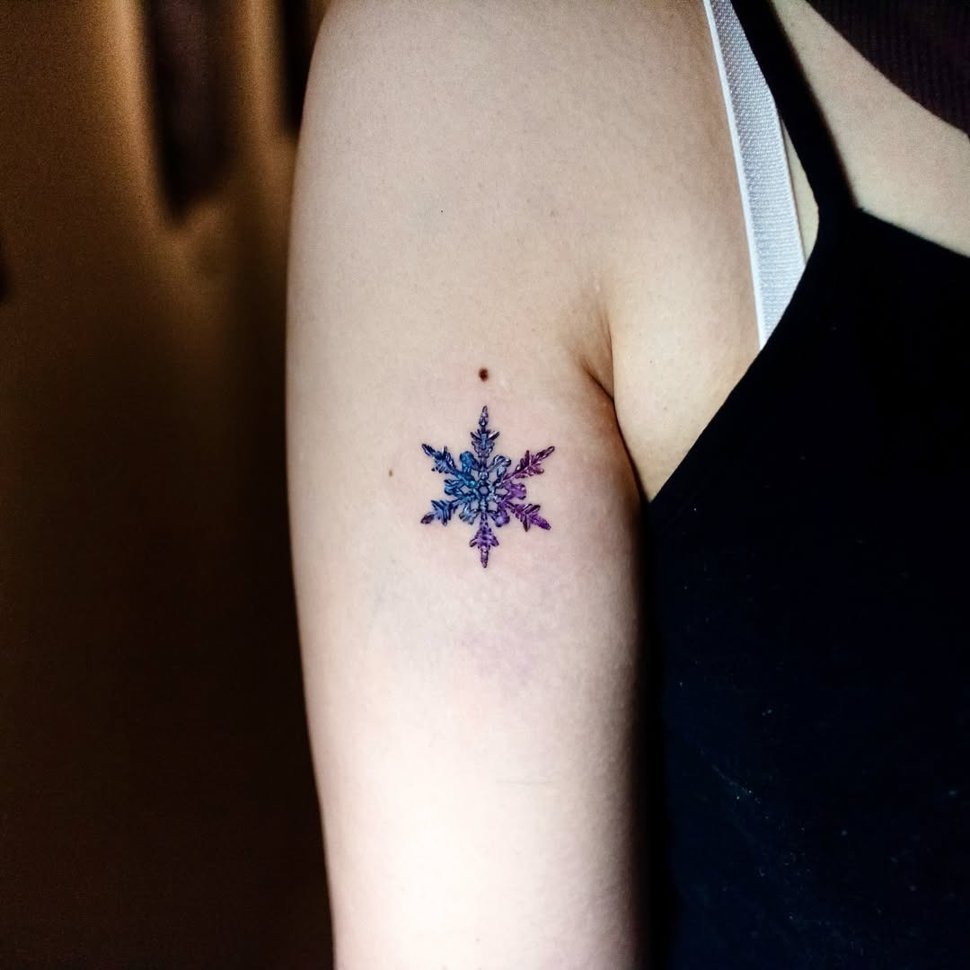 Colorful snowflake tattoo on the upper arm Tattoo Design