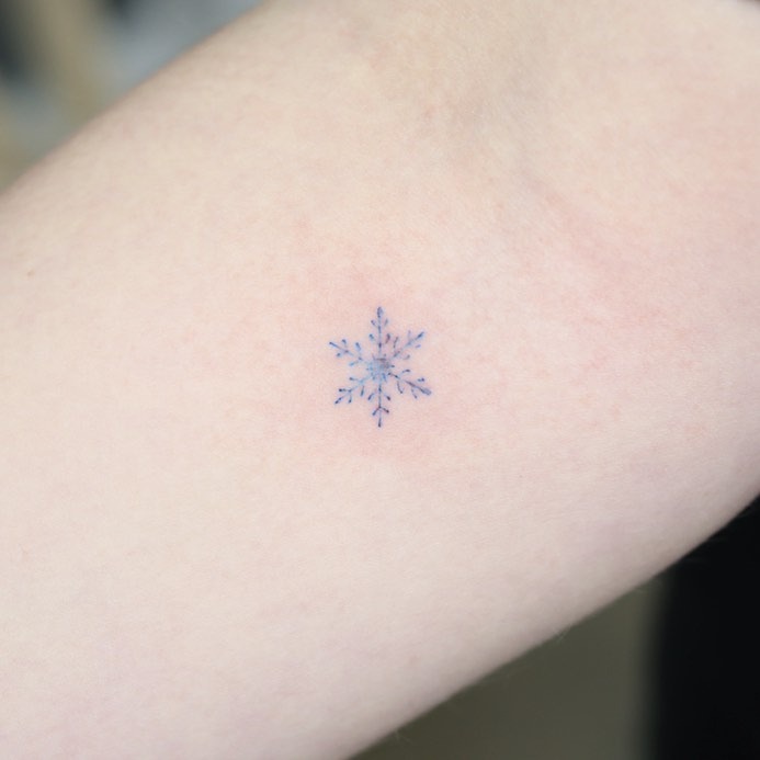 Delicate blue snowflake tattoo on the arm Tattoo Design