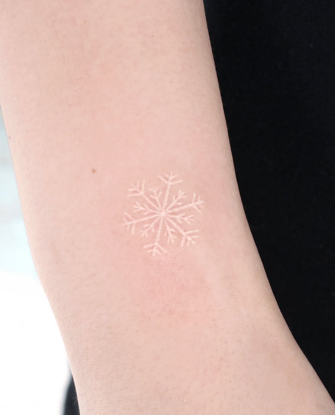 Delicate snowflake tattoo on bare skin Tattoo Design