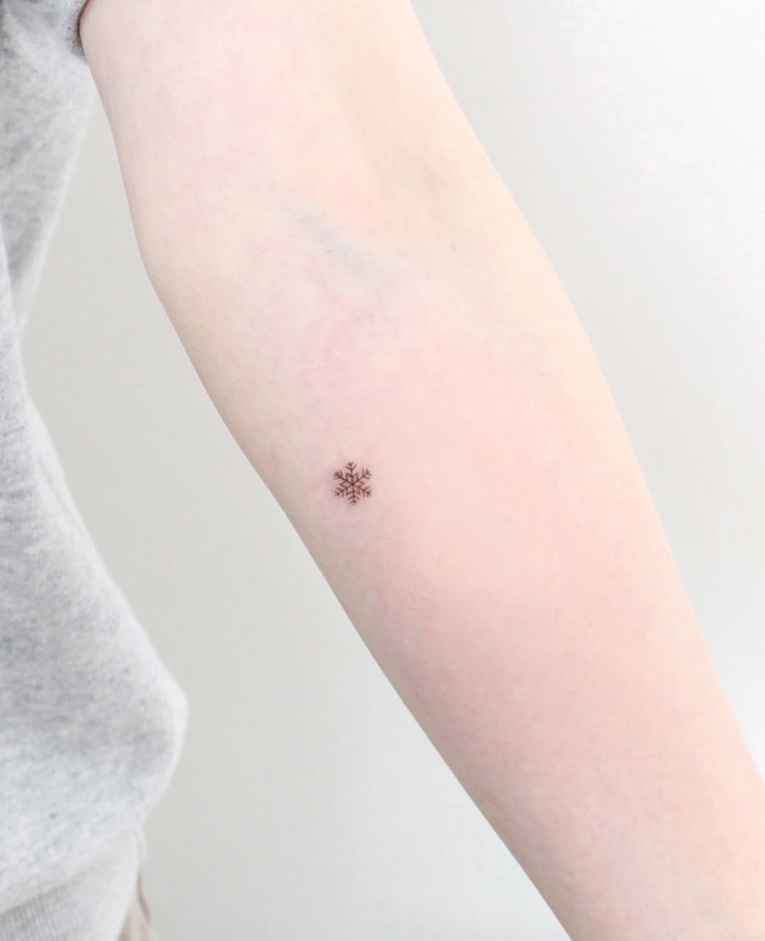 Elegant snowflake tattoo on the forearm Tattoo Design