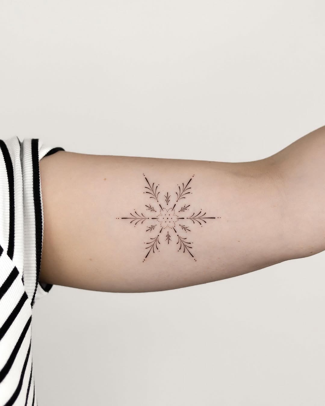 Elegant snowflake tattoo with delicate details Tattoo Design