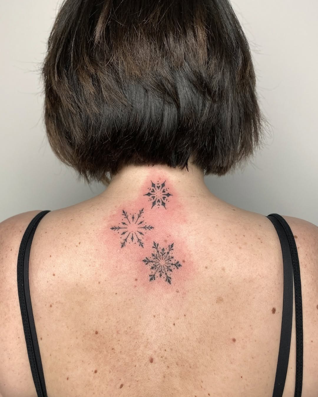 Elegant snowflakes inked on the back Tattoo Design