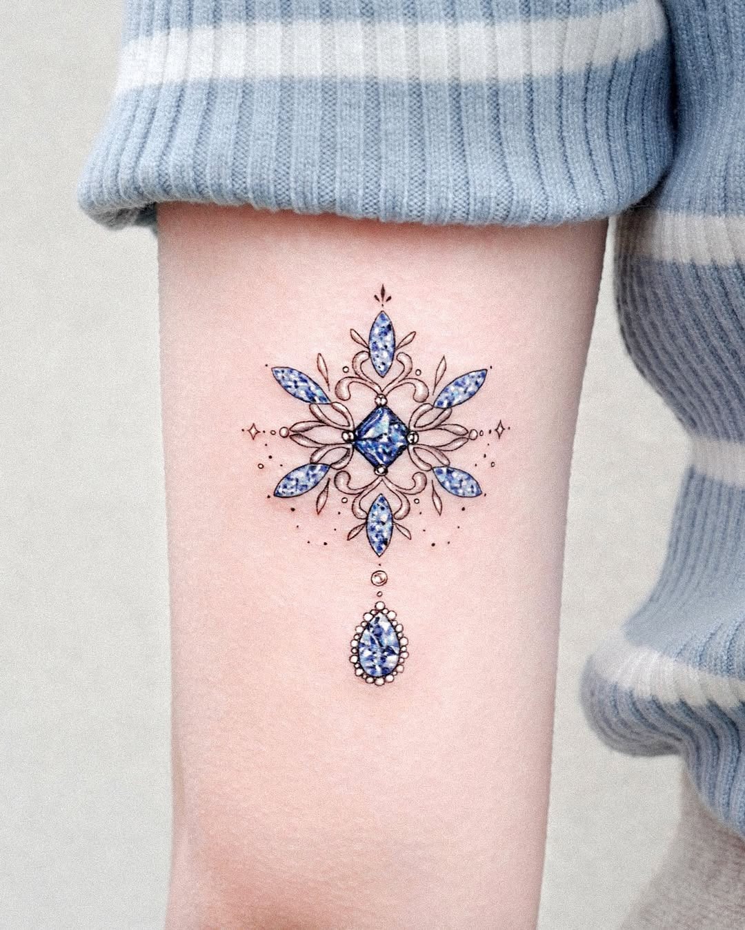 Intricate blue snowflake tattoo with gem-like accents Tattoo Design