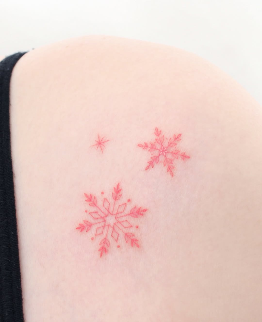 Vivid red snowflakes on subtle skin tone Tattoo Design