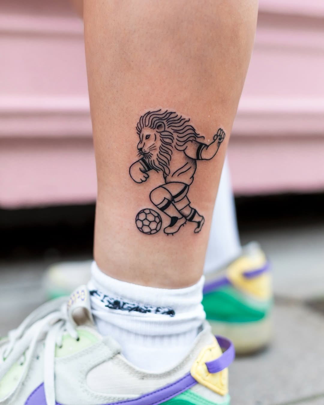 Dynamic lion tattoo showcasing soccer skills Tattoo Design