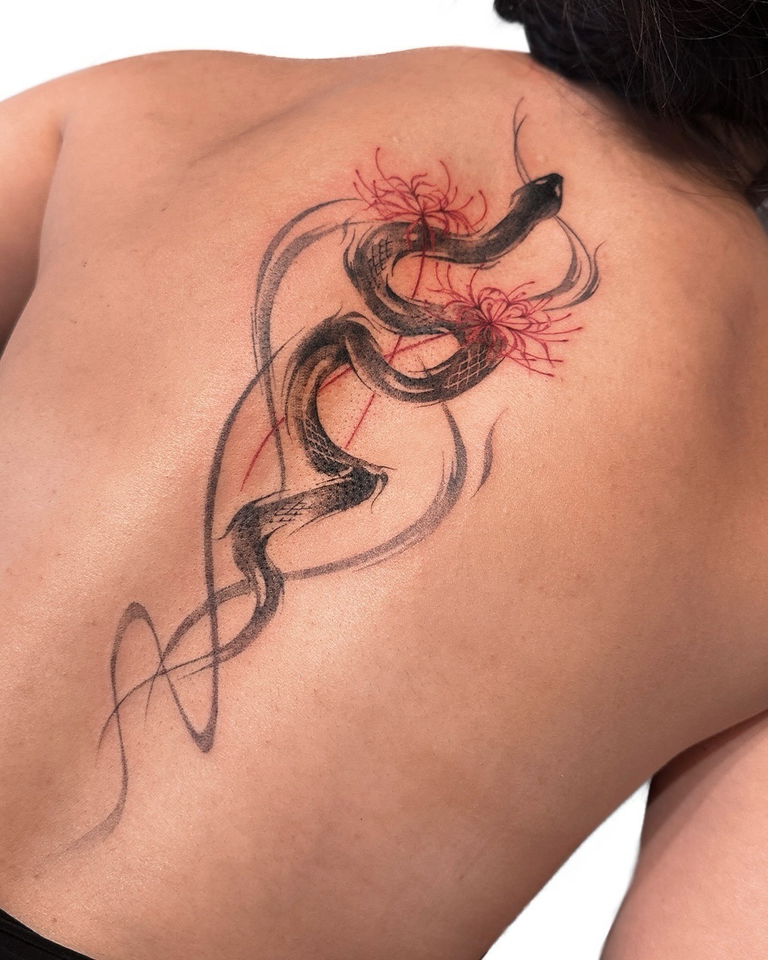Elegant snake tattoo with floral accents Tattoo Design