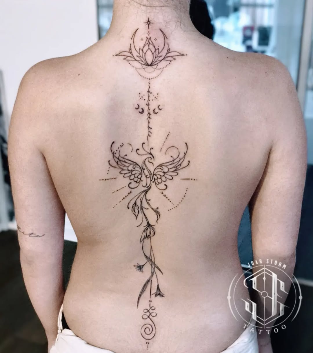Elegant spine tattoo featuring lotus and floral elements Tattoo Design