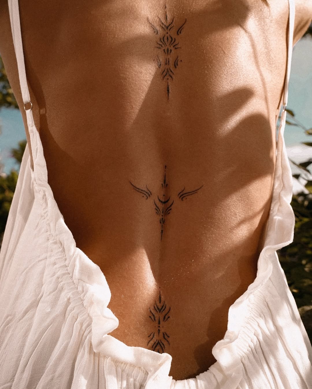 Elegant spine tattoo with tribal motifs Tattoo Design