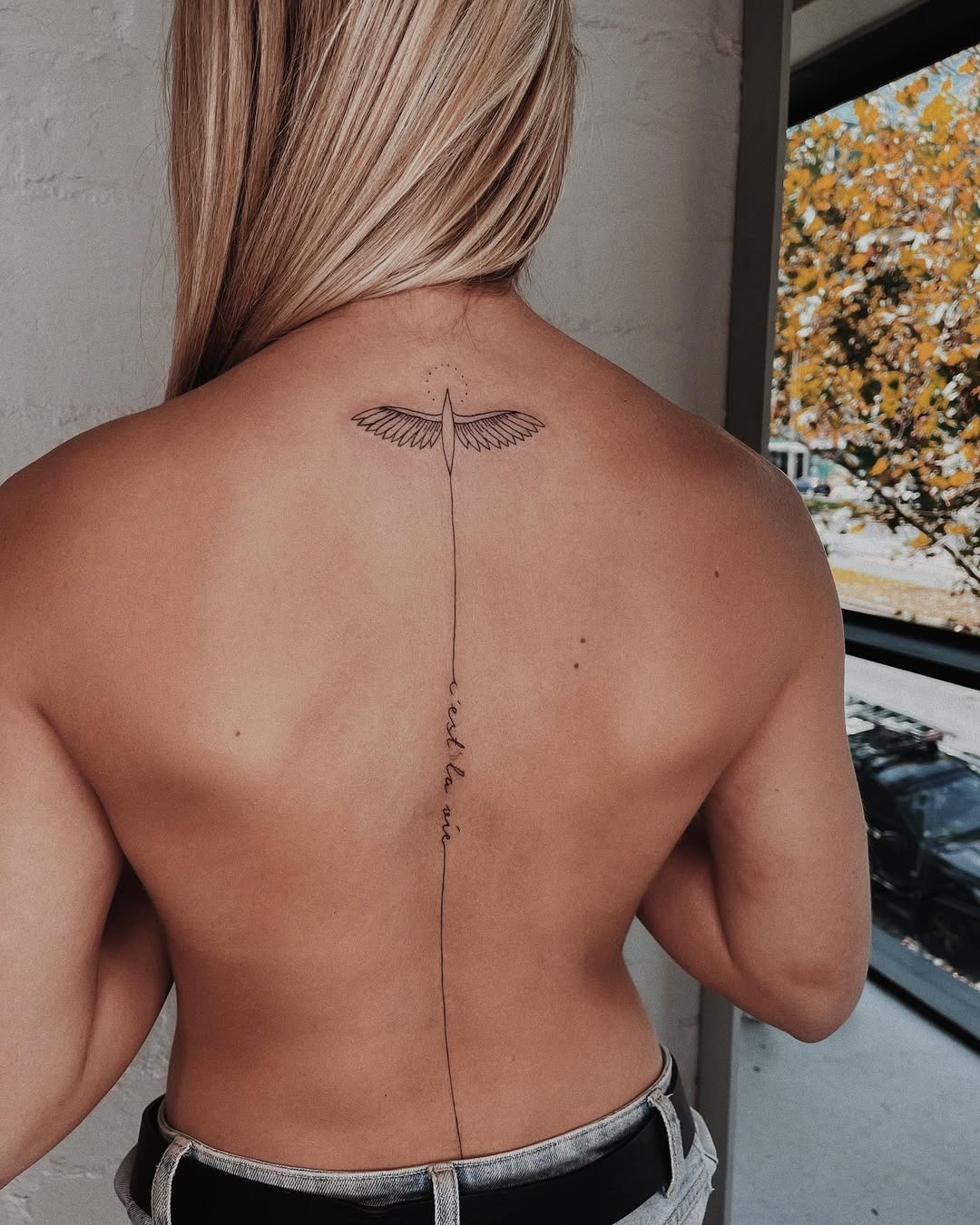 Elegant spine tattoo with wings and script Tattoo Design