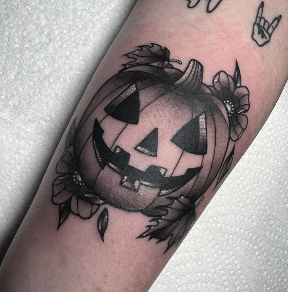 Black and Grey Jack-o'-Lantern with Floral Accents Tattoo Tattoo Design