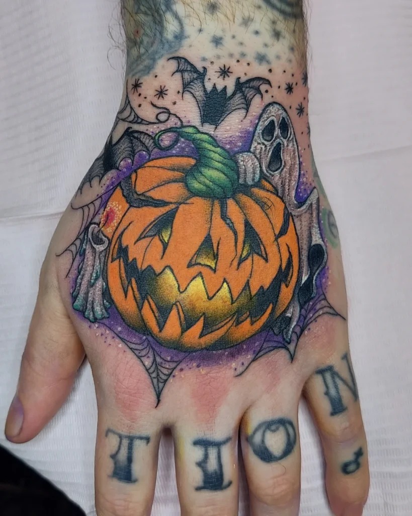 Vibrant Jack-o'-Lantern Hand Tattoo with Ghosts and Bats Tattoo Design