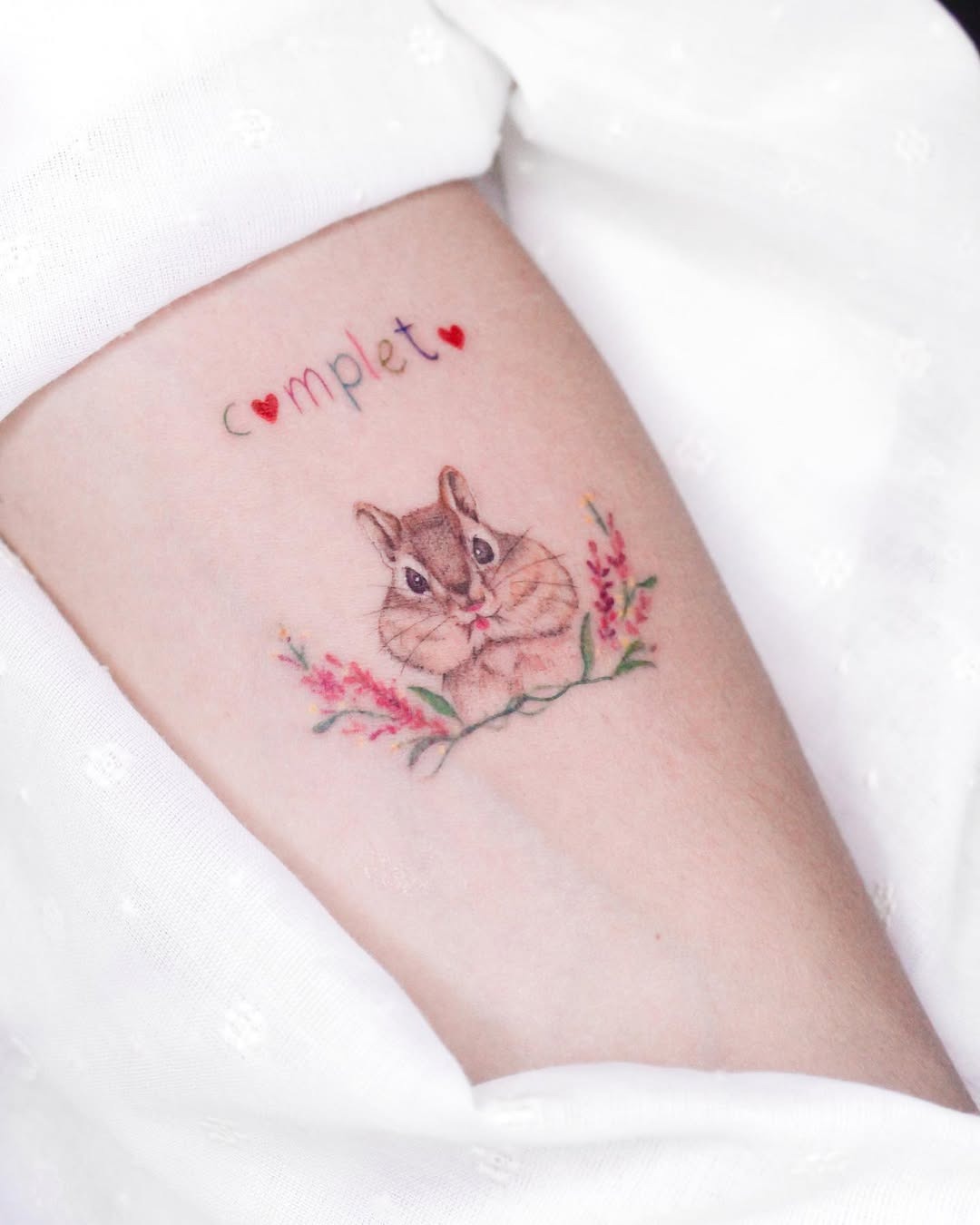 Charming squirrel tattoo with floral accents Tattoo Design