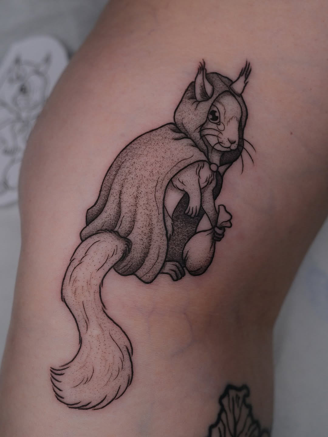Whimsical squirrel tattoo in a cozy hooded cloak Tattoo Design
