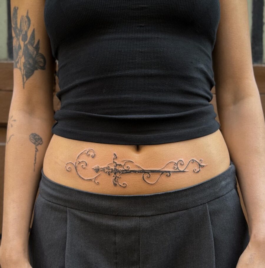 Elegant sword tattoo with floral accents Tattoo Design