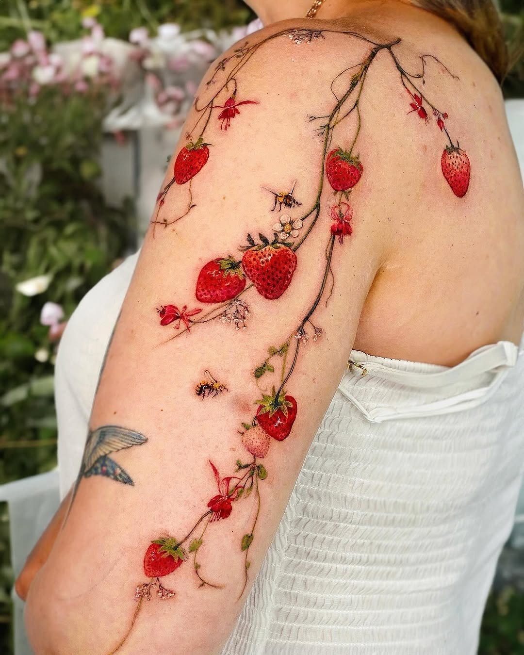 A vibrant strawberry tattoo with floral elements Tattoo Design