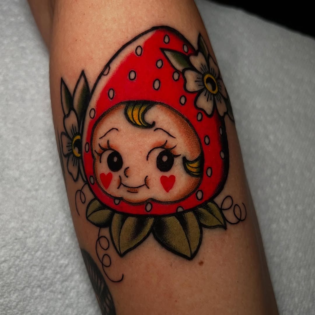 Charming strawberry character tattoo with floral elements Tattoo Design