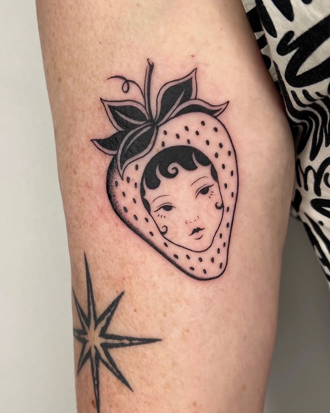 Creative Strawberry Tattoo Featuring a Unique Face Tattoo Design