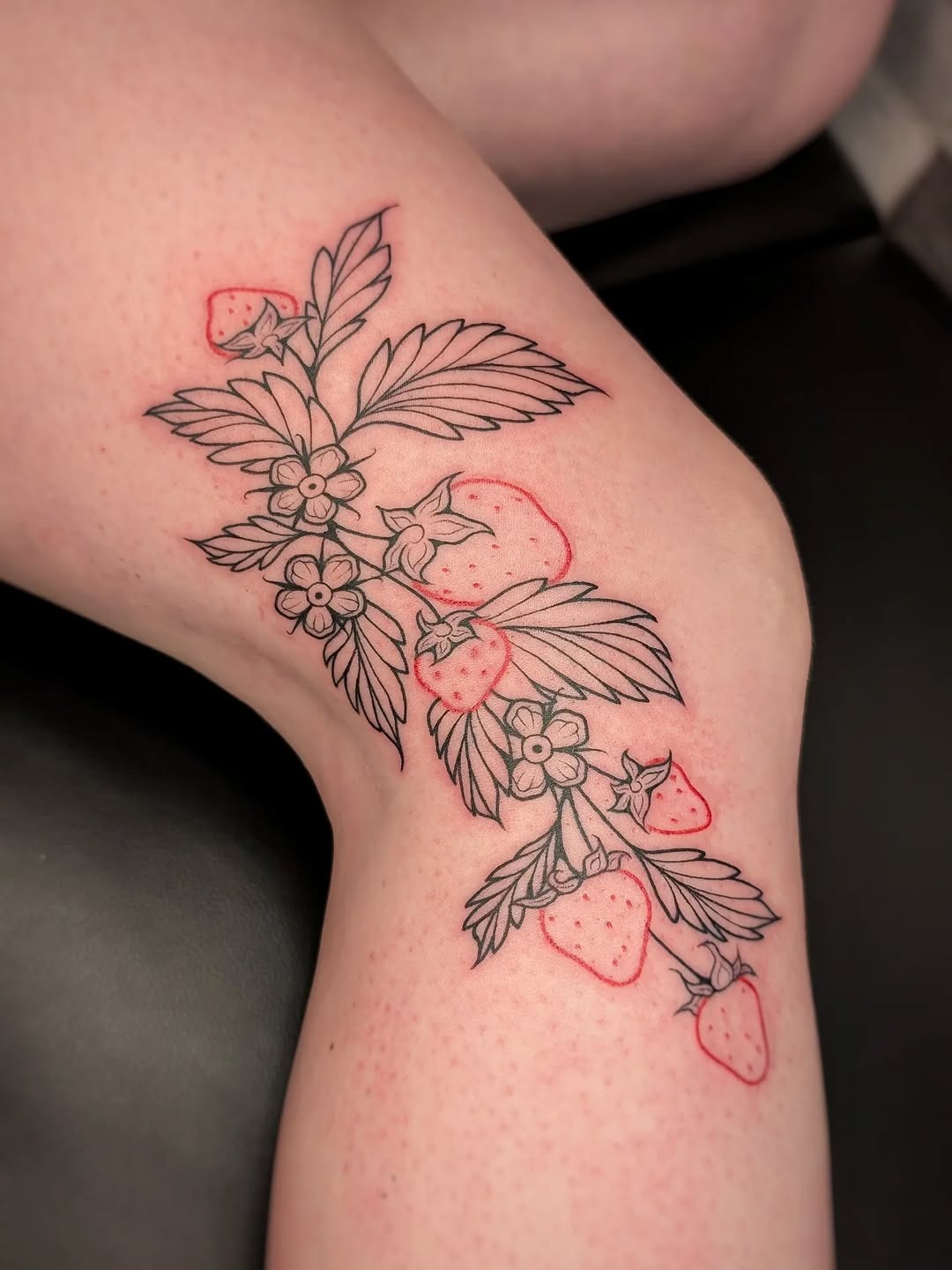 Elegant strawberry tattoo with floral elements Tattoo Design