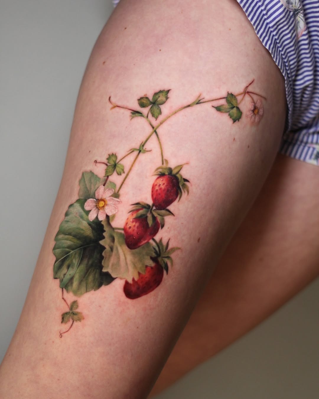 Vivid Strawberry Tattoo with Floral Accents Tattoo Design