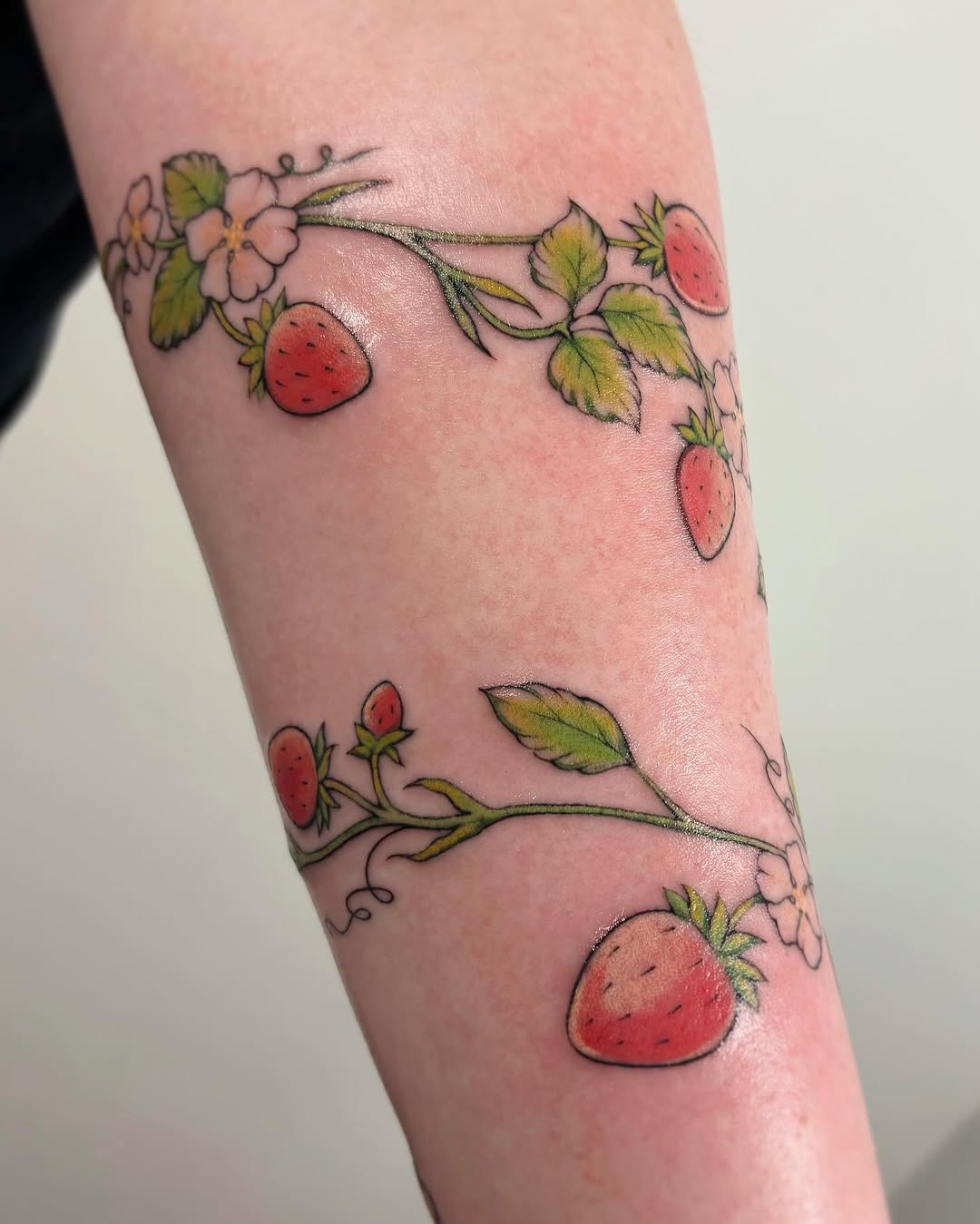 Whimsical strawberry tattoo with floral accents Tattoo Design