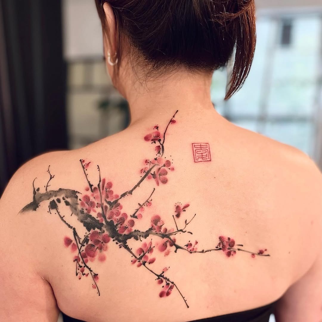 Meaningful strength tattoo featuring elegant depiction of strength through cherry blossoms in bold black ink