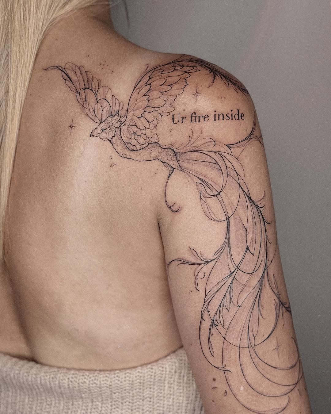 Meaningful strength tattoo featuring elegant phoenix tattoo symbolizing inner strength in bold black ink