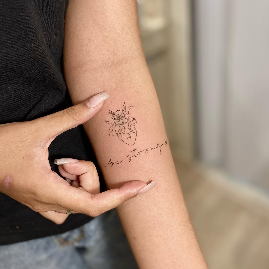 Meaningful strength tattoo featuring elegant reminder of inner strength and beauty in bold black ink