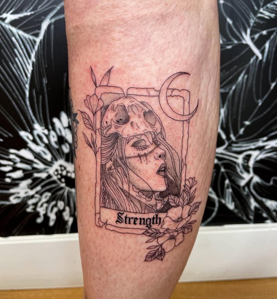Meaningful strength tattoo featuring feminine strength tattoo with floral elements in bold black ink