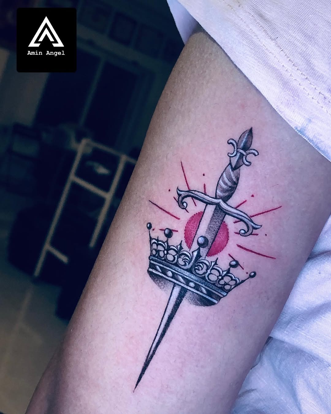 Meaningful strength tattoo featuring symbolic dagger and crown tattoo design in bold black ink