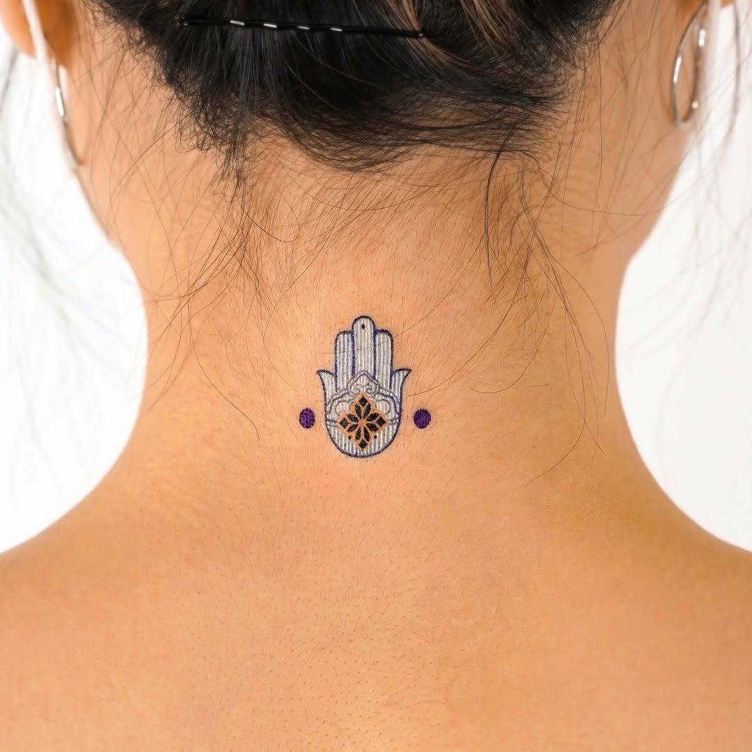 Meaningful strength tattoo featuring symbolic strength through a hamsa tattoo in bold black ink