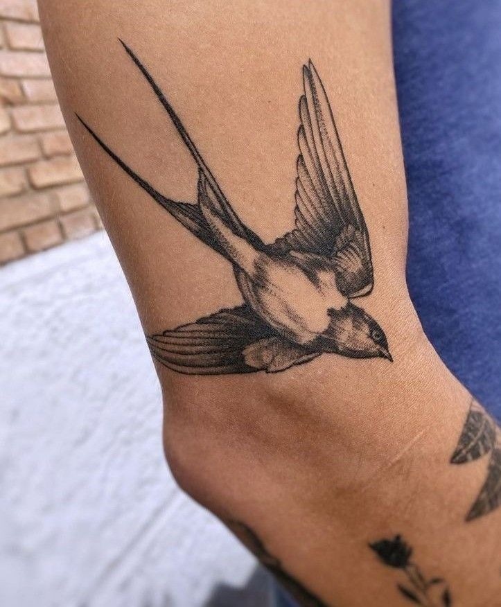 Black and Gray Swallow Flying Across the Arm Tattoo Design