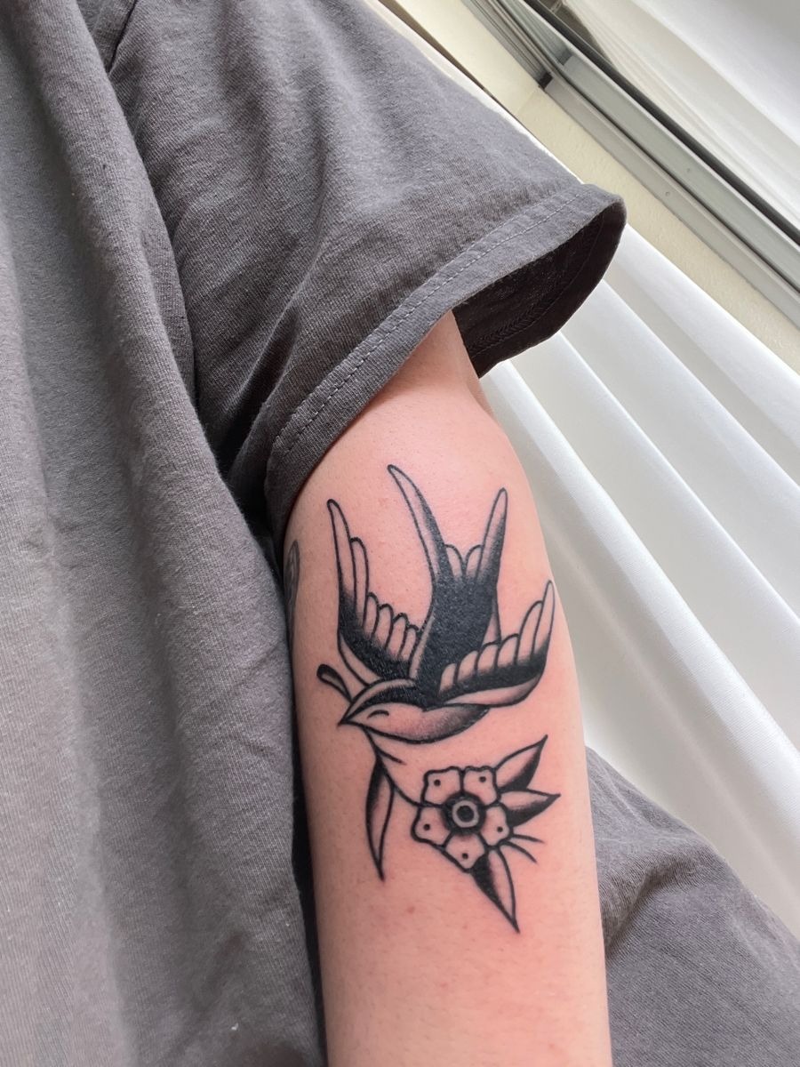 Traditional Swallow With a Simple Flower Tattoo Design