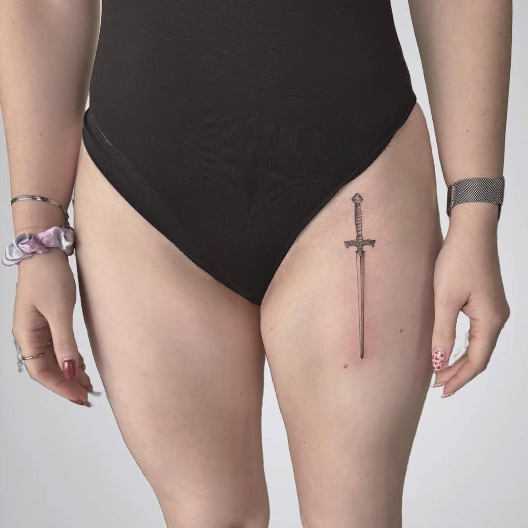 Elegant sword tattoo enhances thigh aesthetics Tattoo Design