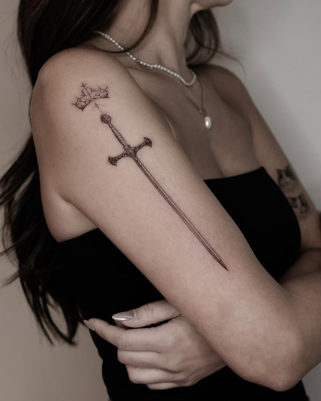 Elegant sword tattoo with a crown design Tattoo Design