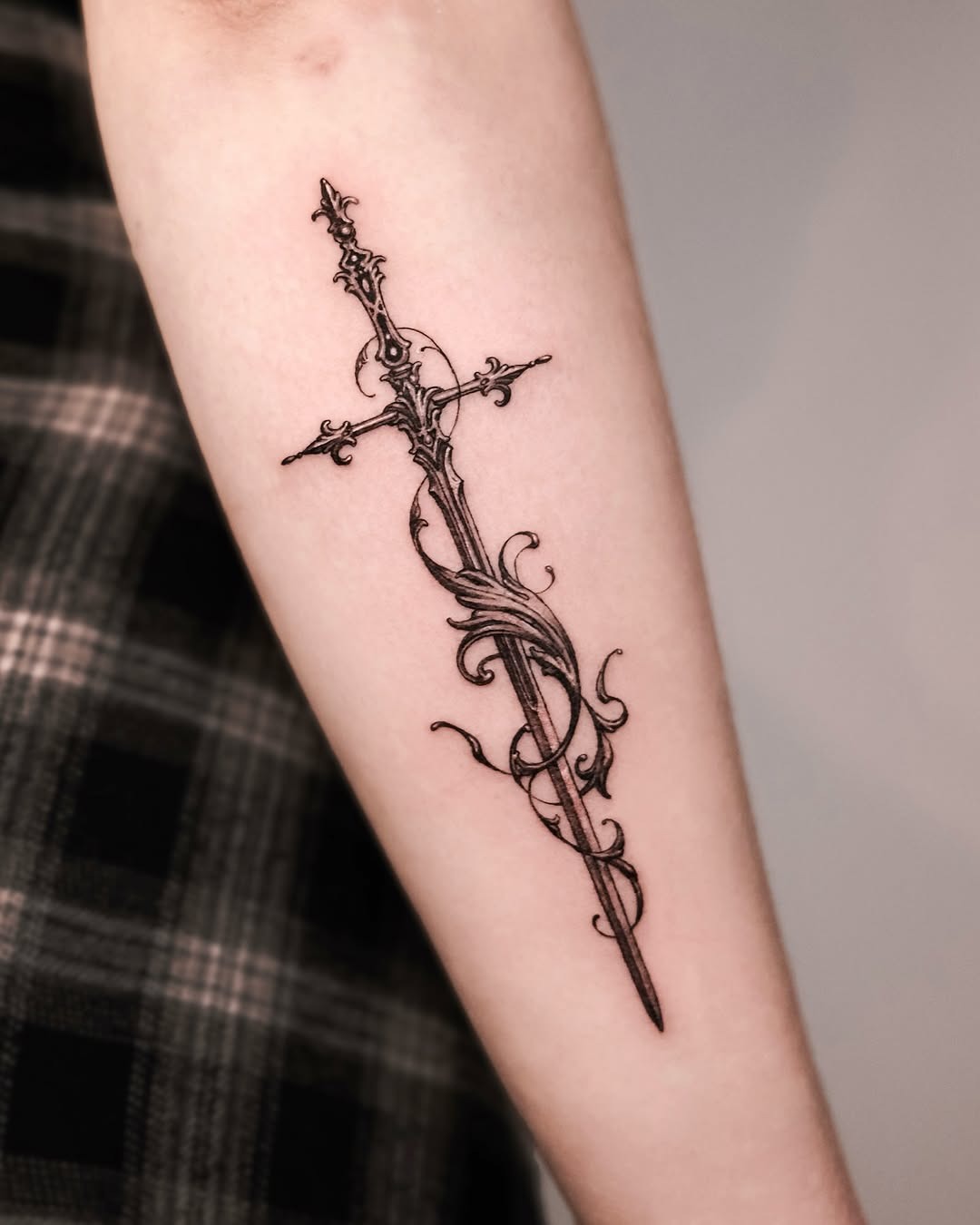 Elegant sword tattoo with floral details Tattoo Design