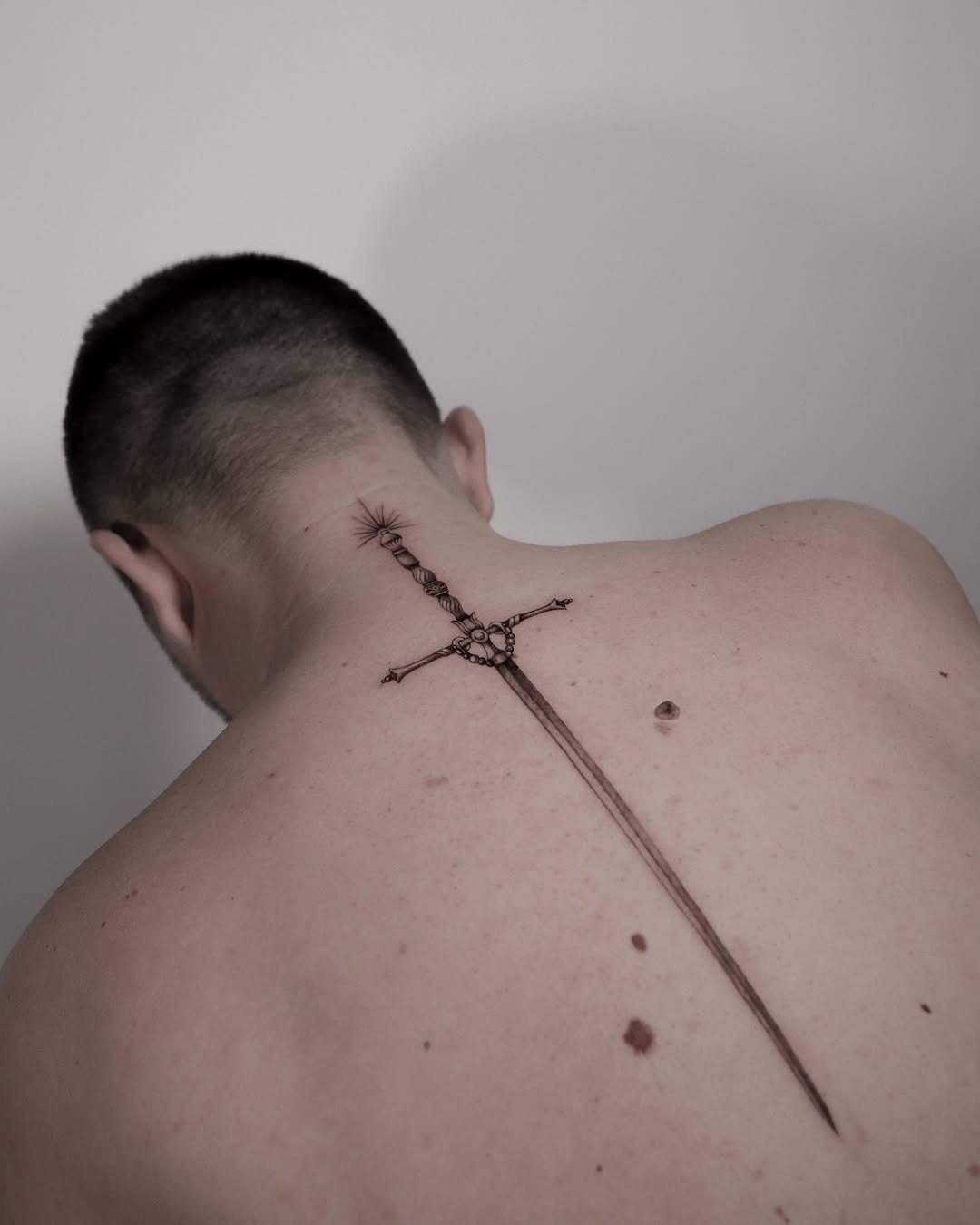 Intricate sword tattoo gracing the back. Tattoo Design