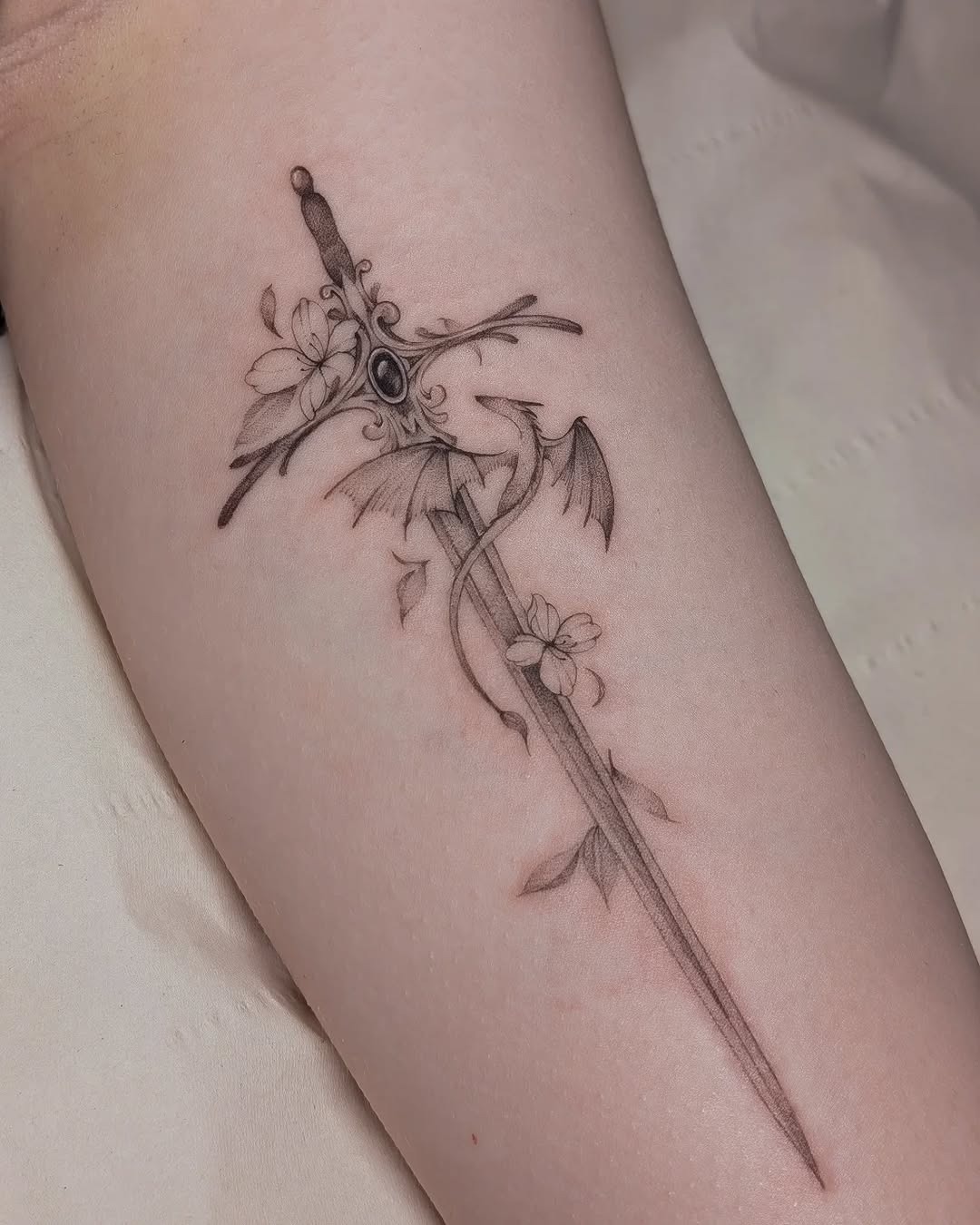 Intricate sword tattoo with floral elements Tattoo Design