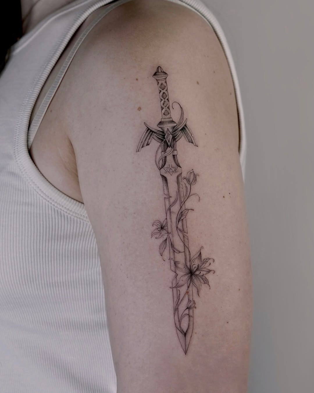 Stunning sword tattoo with floral accents Tattoo Design