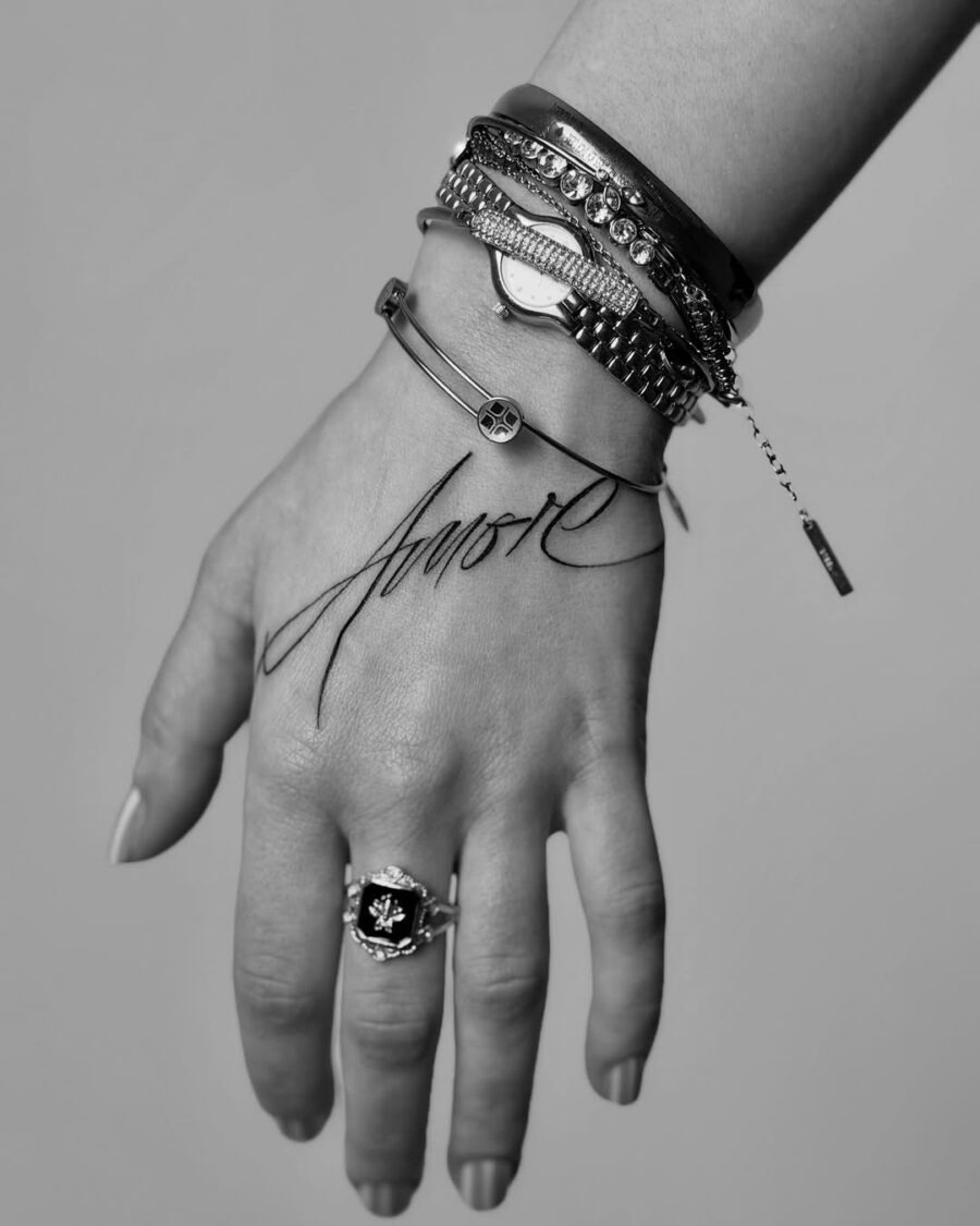 Elegant script tattoo with stylish accessories Tattoo Design
